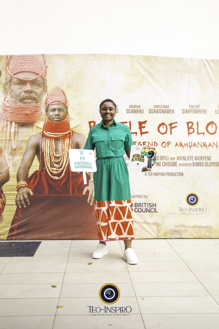 Film Director holding placards with a smile in front of the backdrop